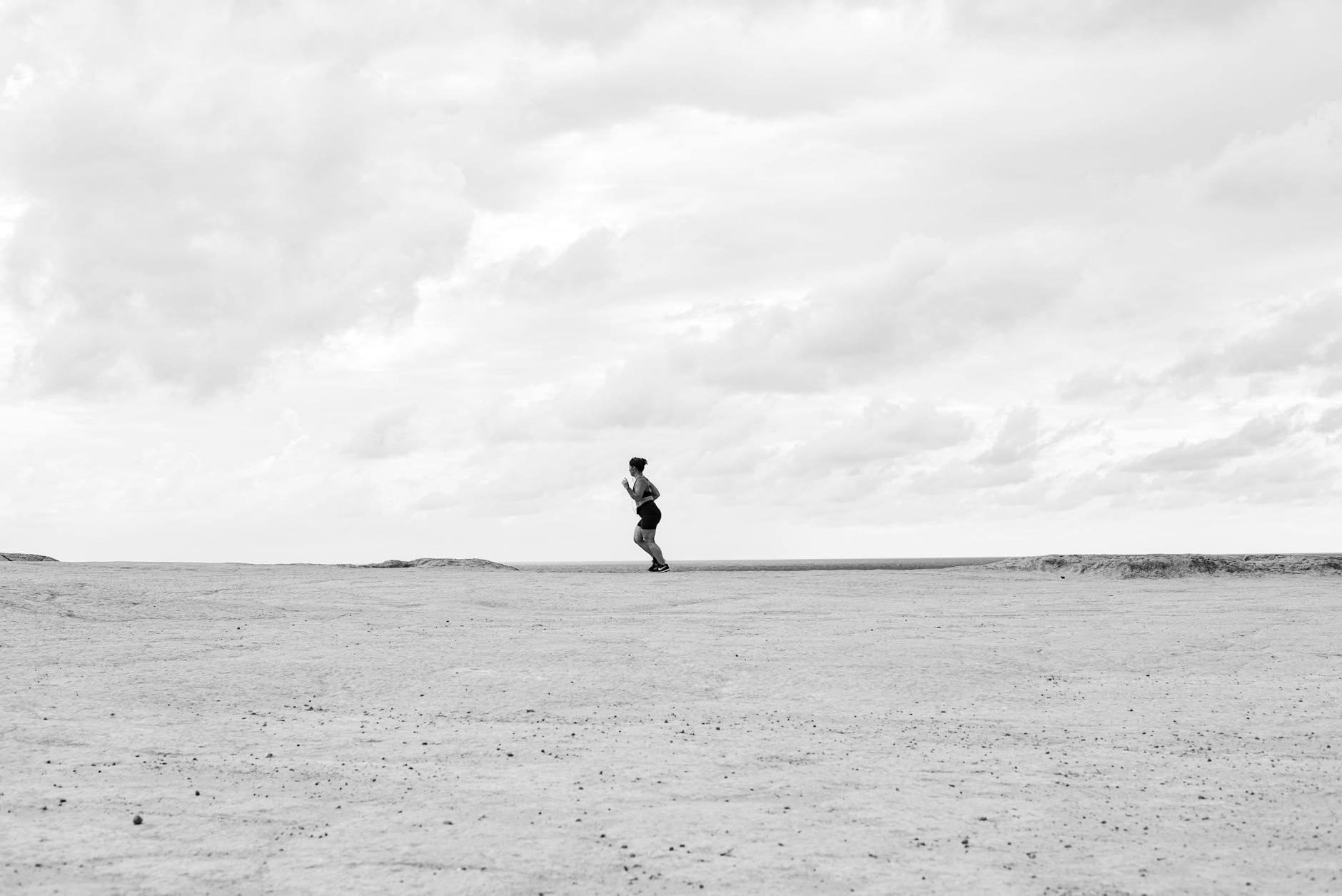 Biegacz samotnie biegnący po pustynnym, otwartym krajobrazie