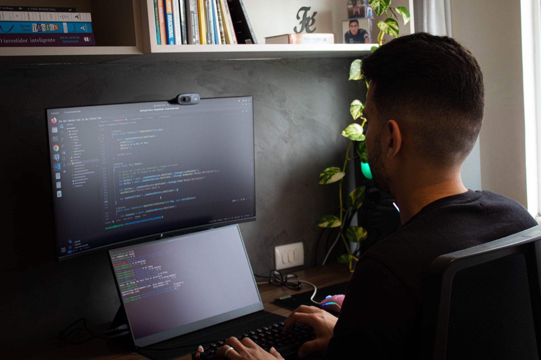 Programista pracujący przy laptopie i monitorze w nowoczesnym biurze