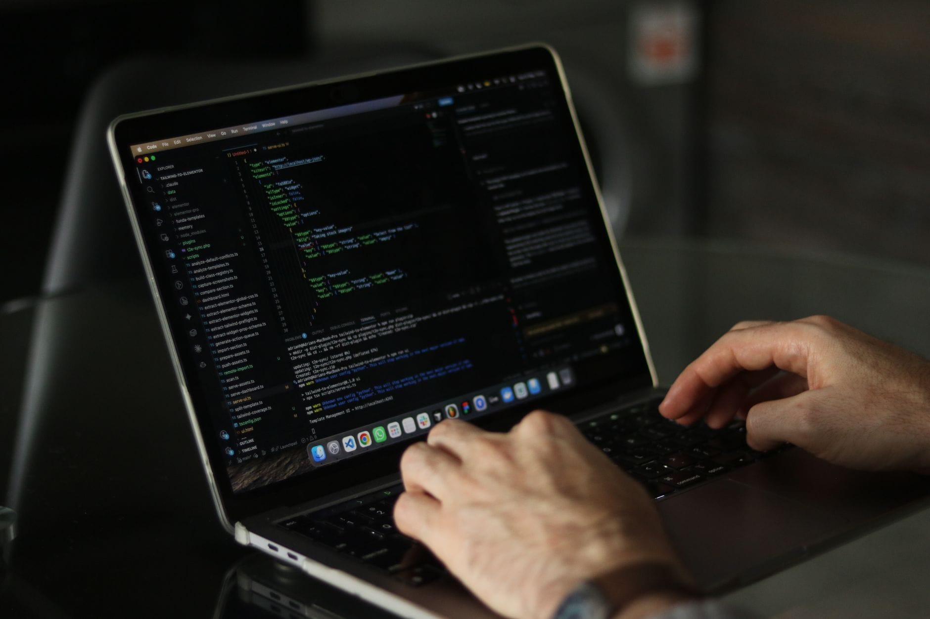 Zbliżenie na dłonie programisty kodującego na laptopie