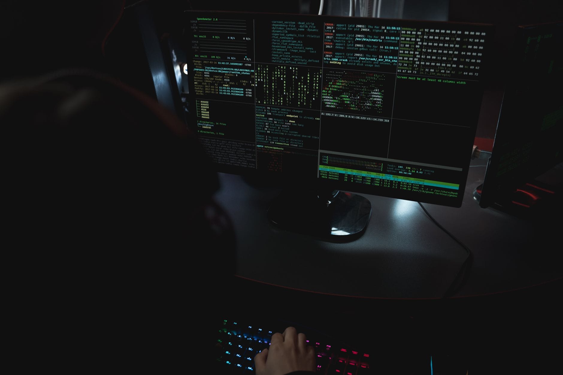 Monitory w ciemnym pokoju z kodem dotyczącym cyberbezpieczeństwa